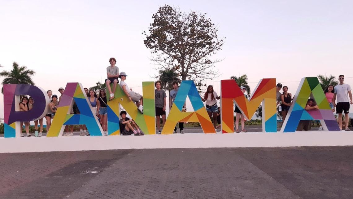 Group of students posed around colourful large letters spelling Panama