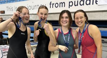 Image of four swimmers with medals