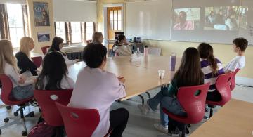 Image of students watching guest speaker on a projector screen